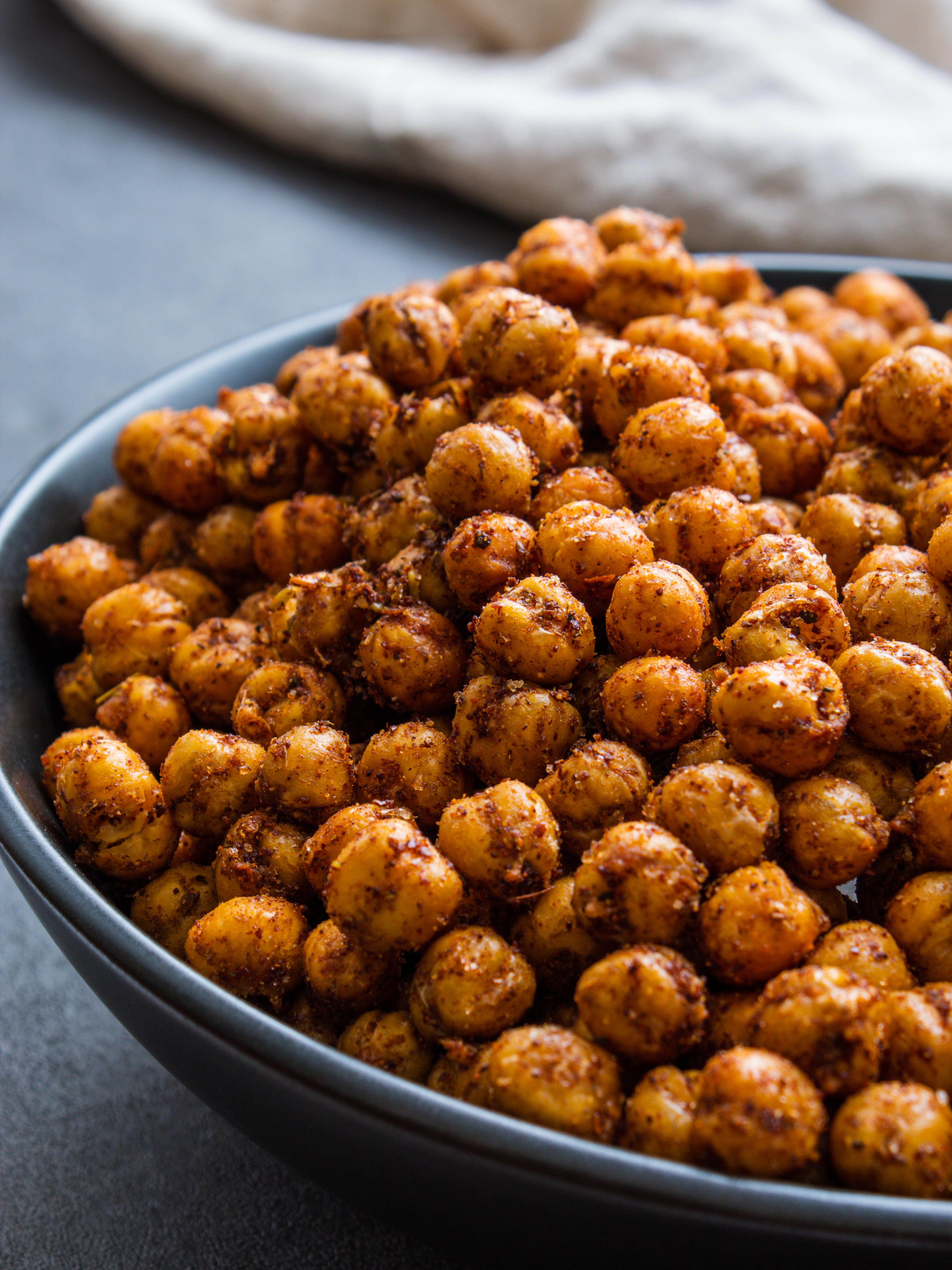 a black bowl full of crunchy air fryer chickpeas coated in Mediterranean spices